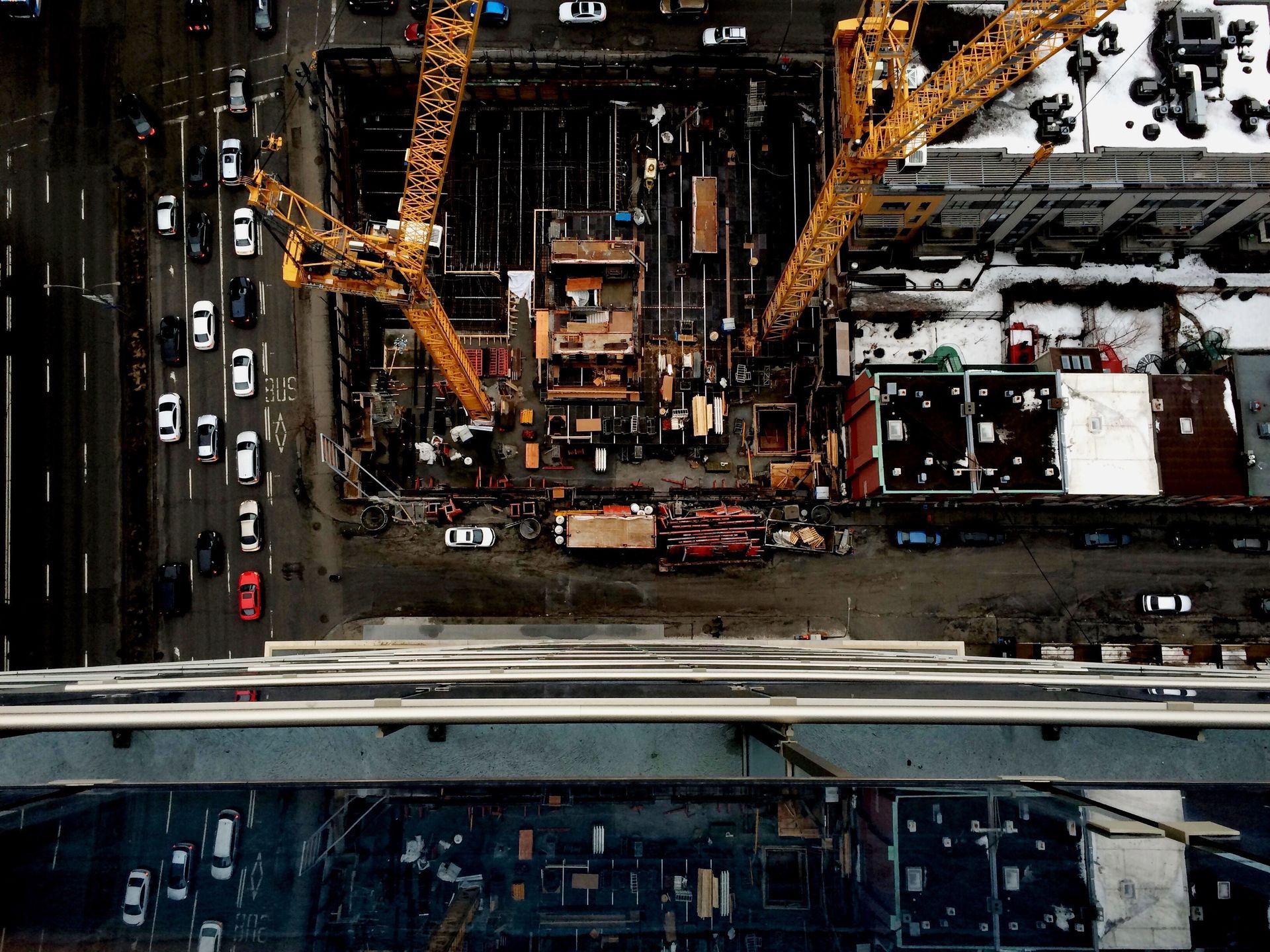 Aerial view looking down on tower cranes over a downtown construction site